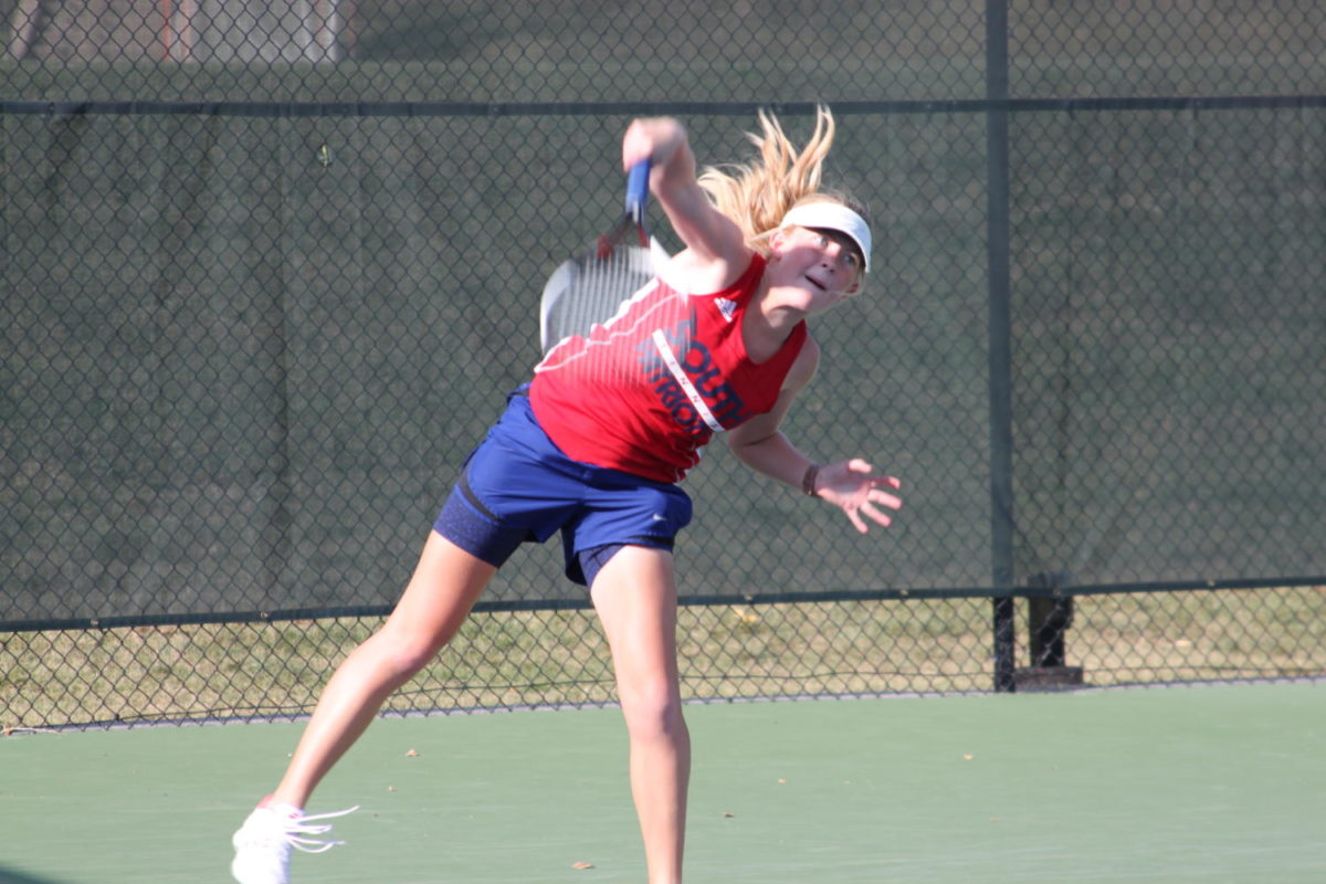 Sophomore Maggie Moore follows through on her serve. 