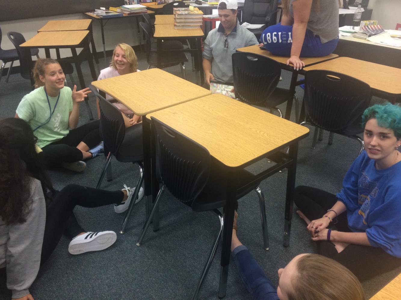 Junior Lauren Twombly, junior Claire Wallace, sophomore Kaden Hubbard, and sophomore Ollie Gray make themselves comfortable on the floor while discussing the aftermath of the Jason Stockley trial during a Youth United meeting.