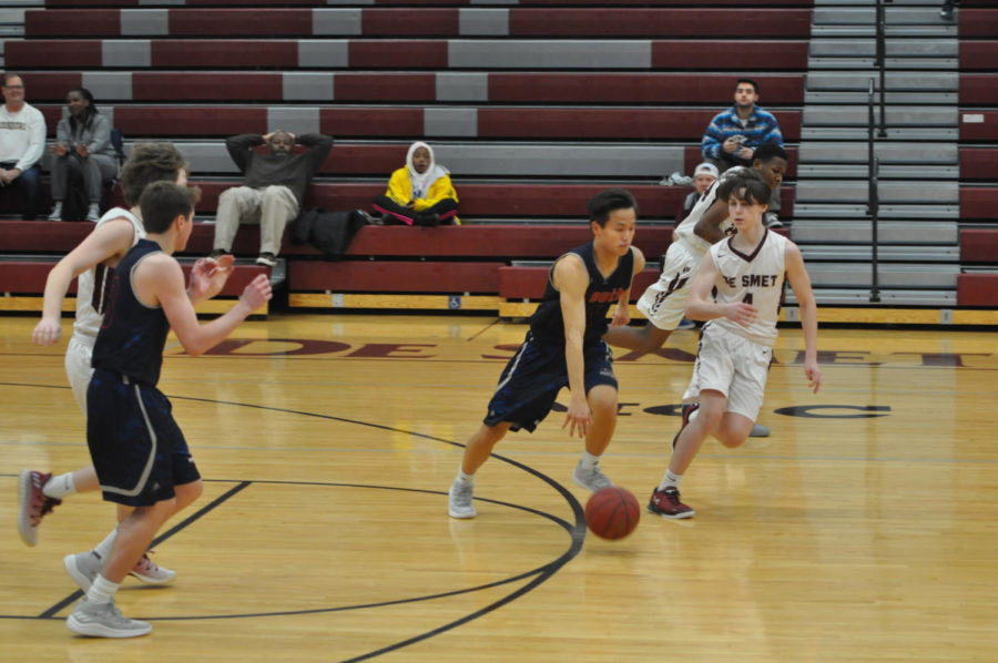 Junior+Dominic+Gong+races+past+his+DeSmet+opponent+with+the+ball%2C+Dec.+12.+The+Patriots+lost+to+the+Spartans%2C+56-53.