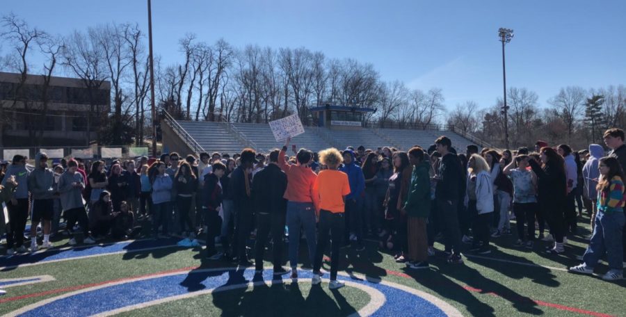 Students converge on the football field during walkout. 