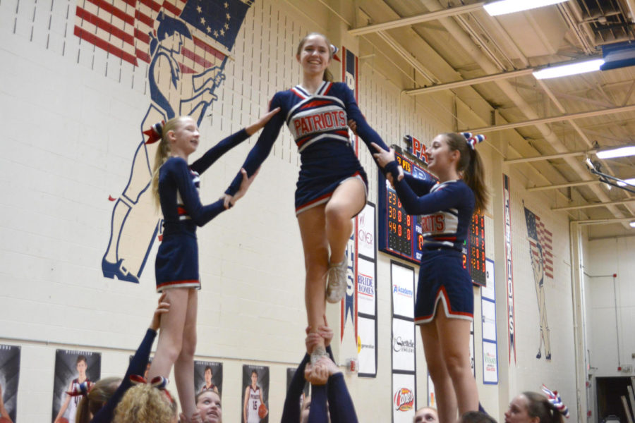 Sophomore Lauren Stark executes a Lib while being supported by freshman Kaylin Day and junior Hailey Markowitz. 