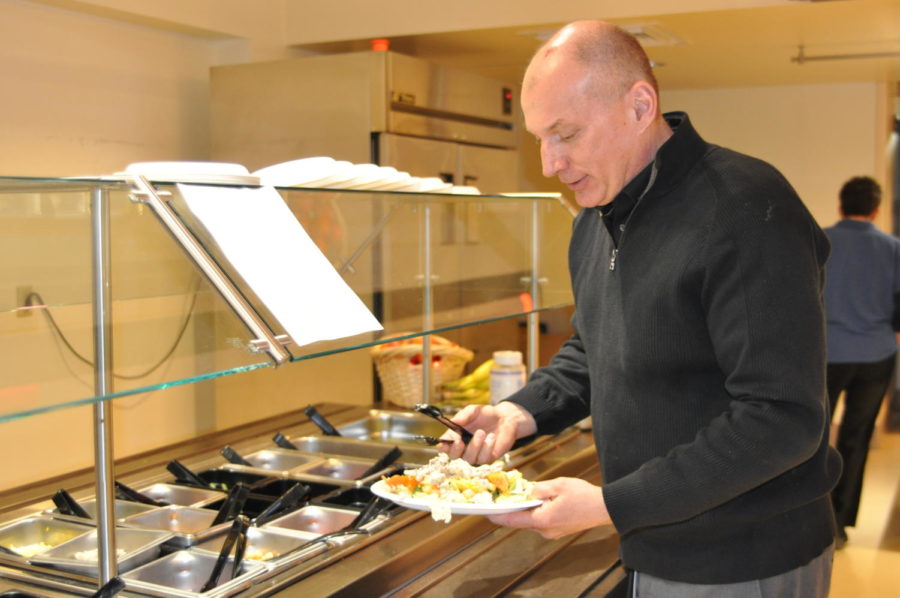 Business teacher Robb Bock fills his plate at the salad bar during lunch. Many students make New Years Resolutions to eat  healthier.