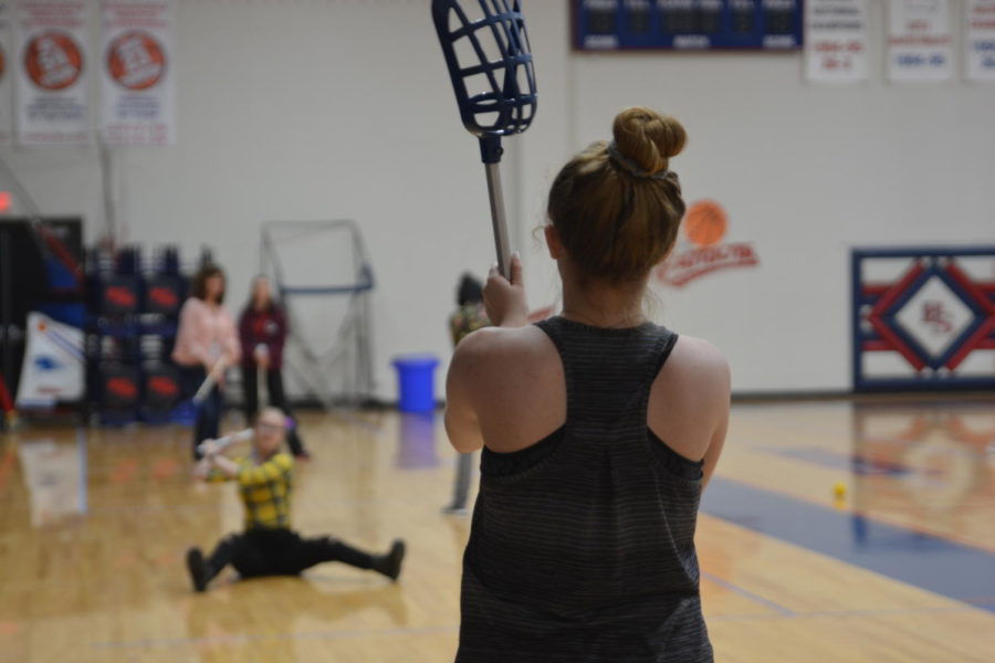 Two students play catch with a lacrosse ball during Mr. McFarlands 5th block Lets Move Together class. Starting in 2020, students will be able to take P.E. courses online. 