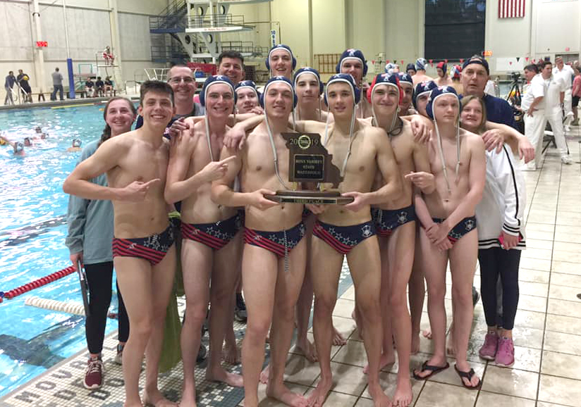 Members of the varsity water polo team hold up their third place trophy. 