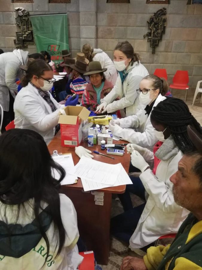 Junior Iris Cameron and other nurses and volunteers prick peoples fingers to test for Anemia and Diabetes. Cameron traveled to Peru over the summer to learn more about medicine.