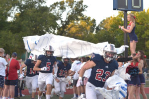 Seniors Nolan Lombardo and Jack Crayton lead the Patriots onto the field at the teams first home game against Northwest, Sept. 6.