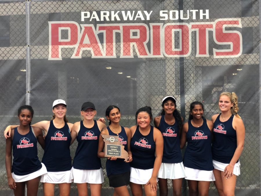 Members of the varsity girls tennis team hold their trophy for winning the district tournament.