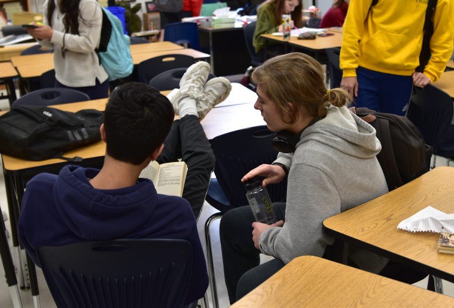 Junior Nils Krueger talks with a student during class. Krueger is from Germany and is not used to American intruder drills.