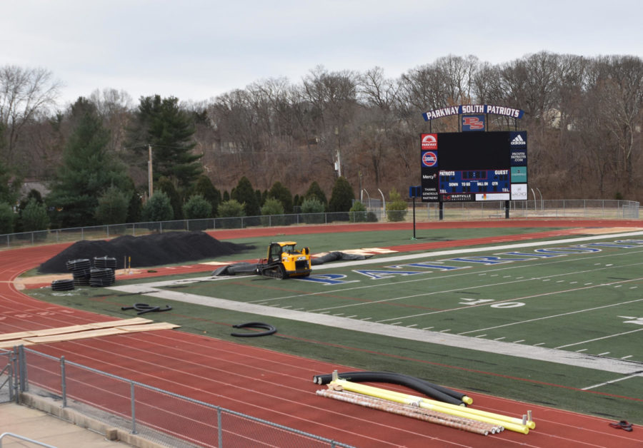 Workers prepare to remove the old turn field so they can install the new field. 