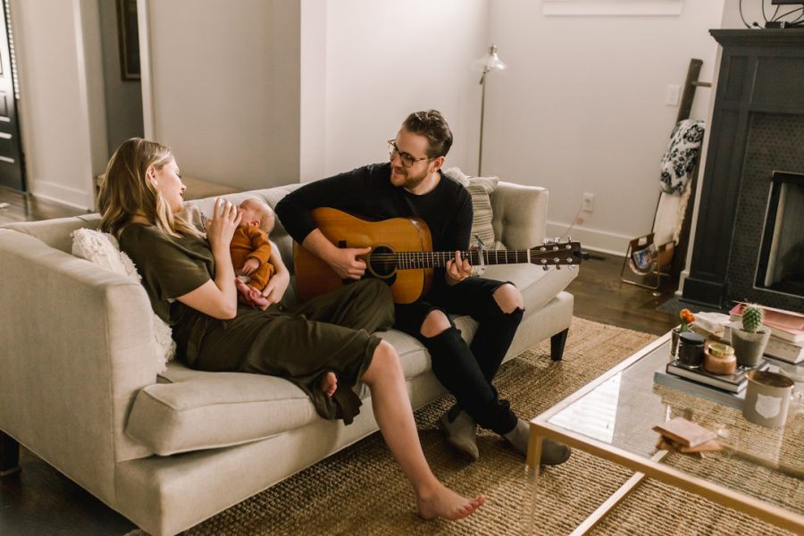 2007 graduate Jordan Reynolds plays a song for his wife and baby at their home in Nashville.