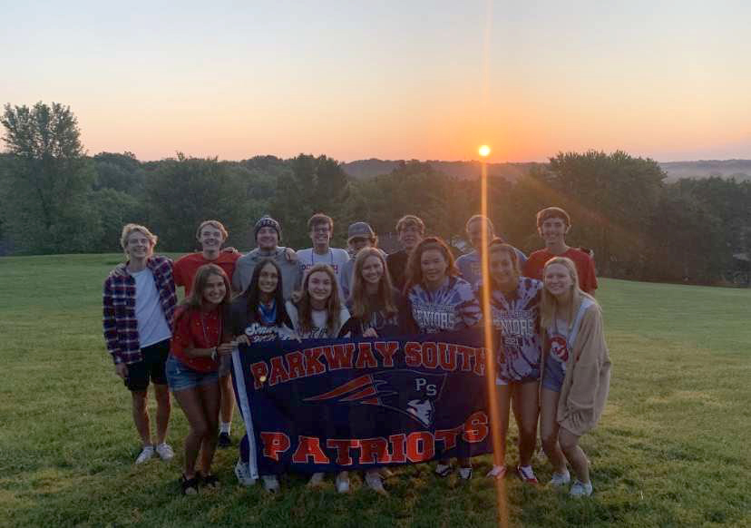 Seniors pose for a picture with the sunrise in the background on the first day of school. 
