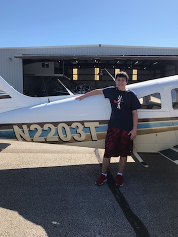 Junior Kevin Cole stands next to a Piper Cherokee airplane--one of the planes hes flying to earn his pilots license. 
