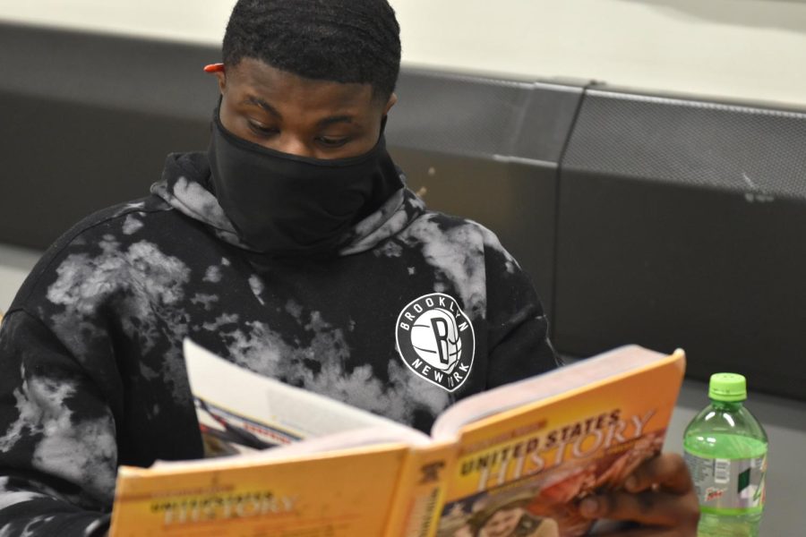 Freshman Zyon Thompson wears his mask while reading in Ms. Hubbard's Modern U.S. History class.
