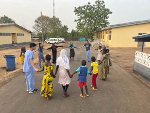 Freshman Sameer Power holds hands with children in Ghana while on a medical mission trip. 