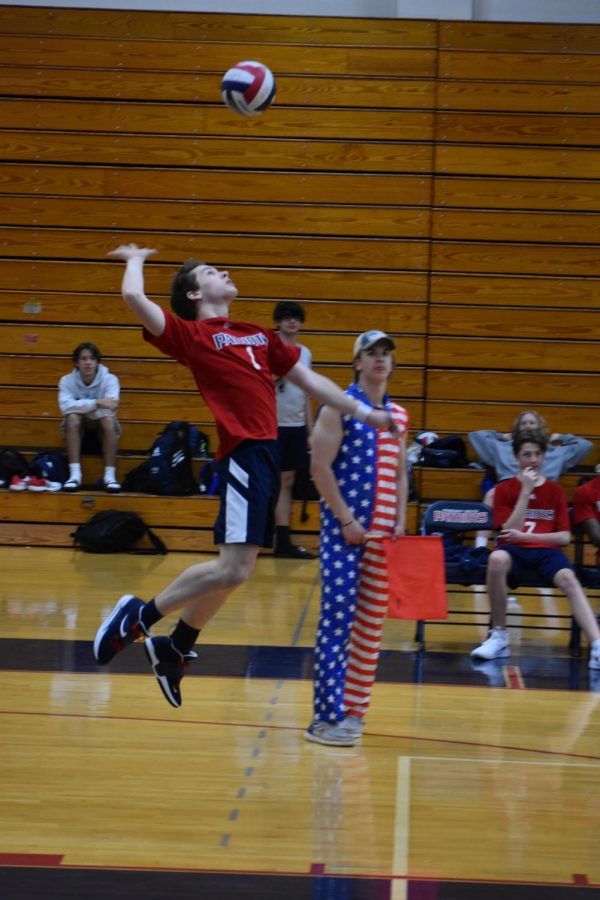 Sophomore Tyler Gregg leaps high in the air to serve the ball over the net in a match against Marquette. 