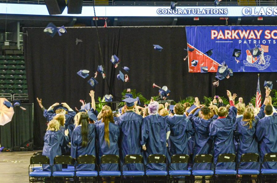 2022 graduates throw their caps in the air after the ceremony is over.