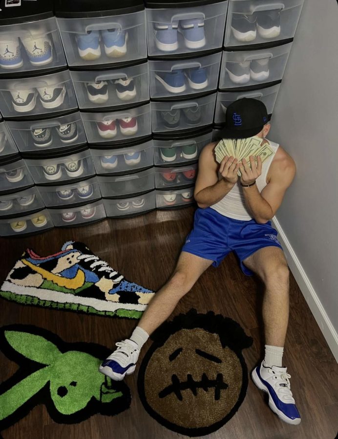 Sitting in front of his sneaker collection, senior Zeke Gould shows off the money hes made by selling shoes. 