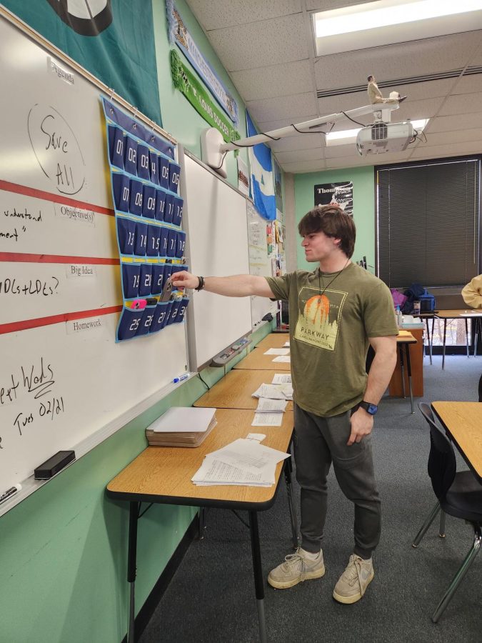 At the end of class, junior Caleb Schellman reaches for his phone in Mr. Morris AP Human Geography class. 