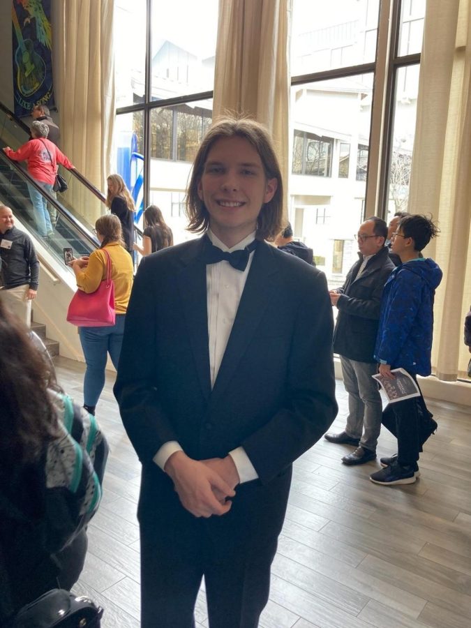 Dressed in his tuxedo, senior Reese Rich poses for a picture at the all-state orchestra concert.