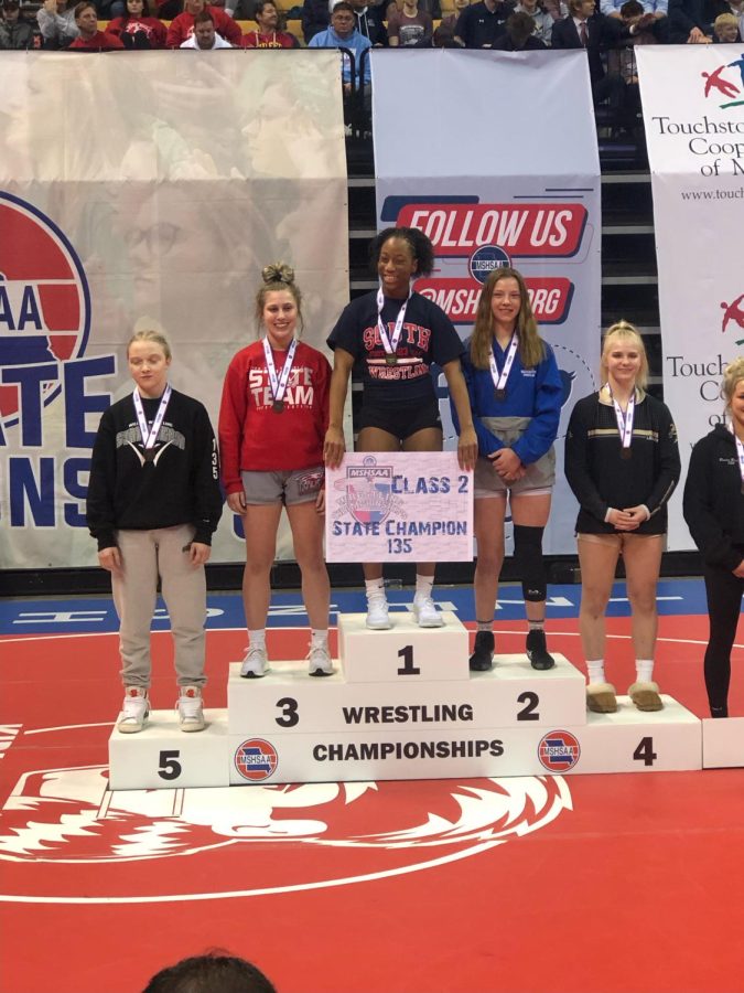 Senior Janiah Jones holds her winning bracket while on the first-place podium at the State Championship.