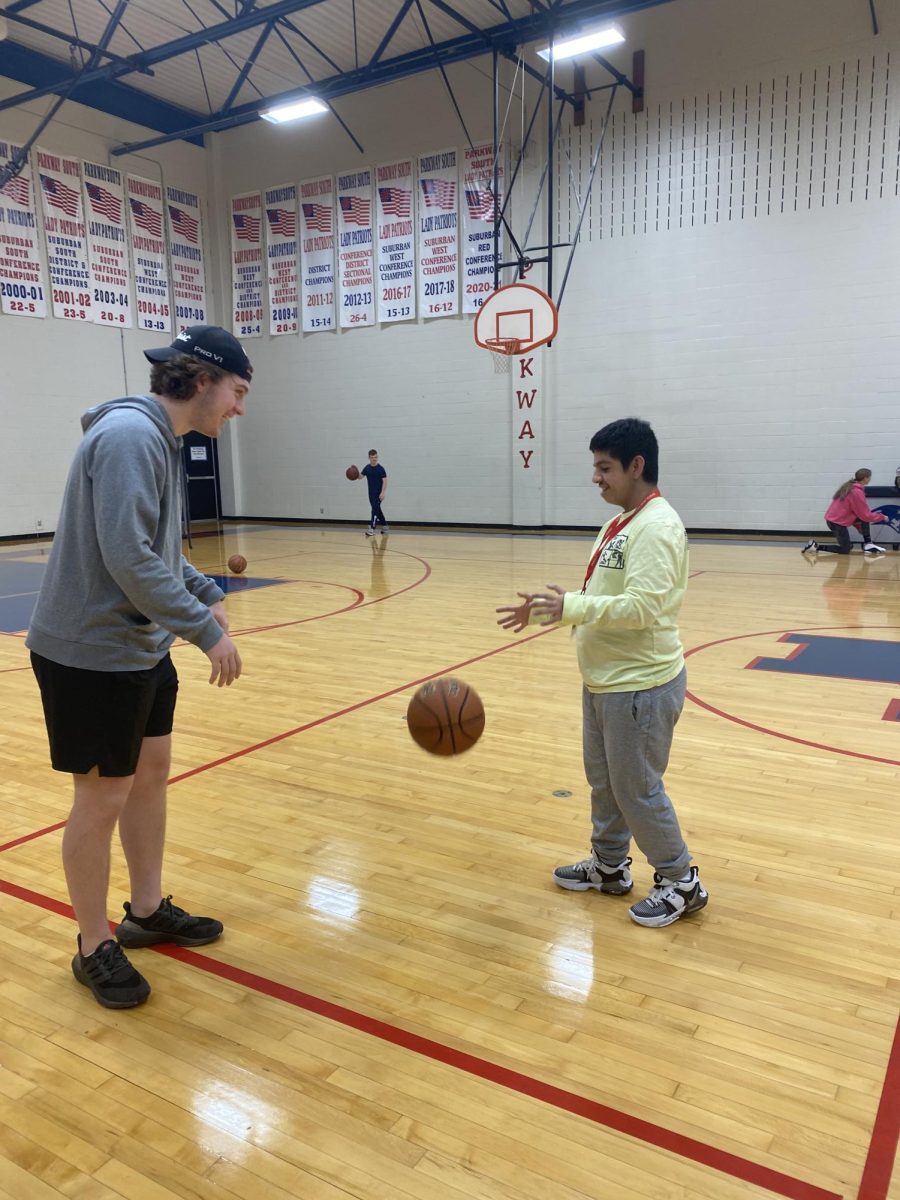Senior Jamison Gifford and junior Simon Tanin play basketball together during free time at the end of PE Mentor class.