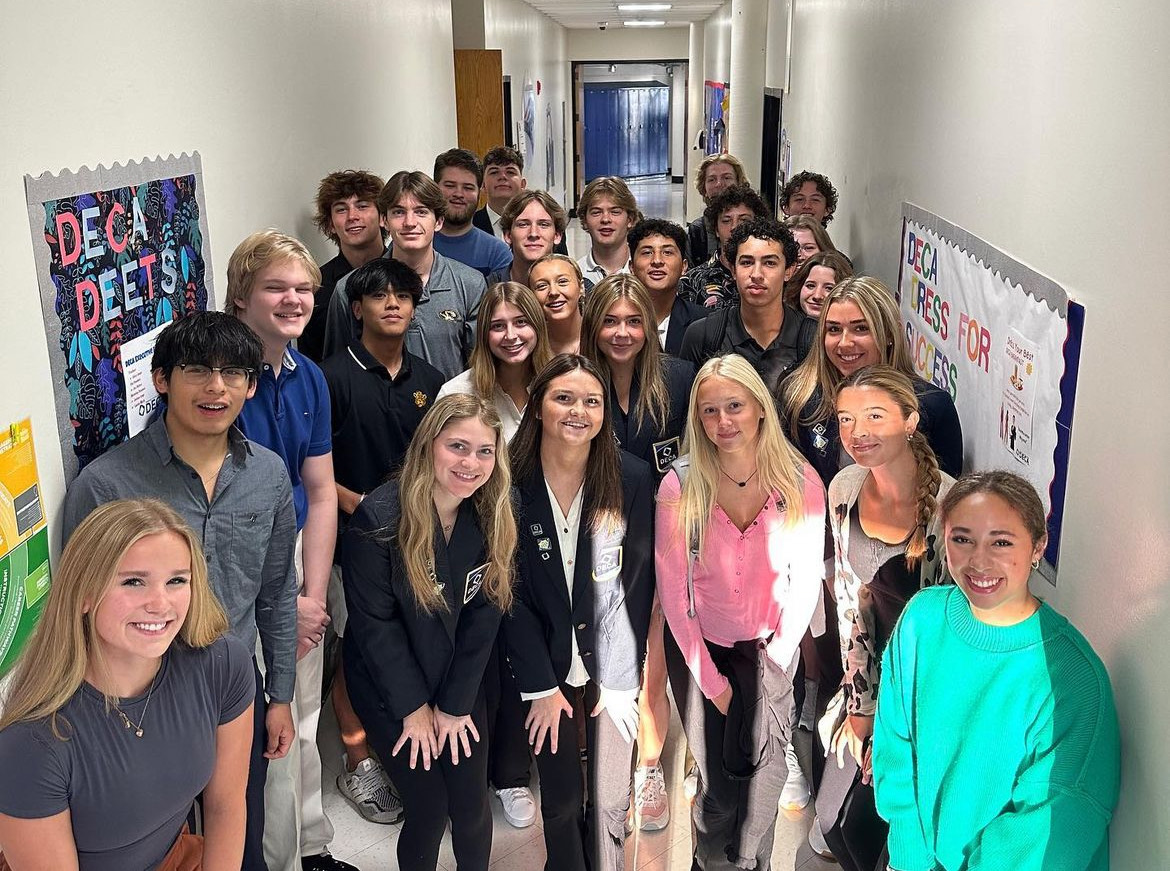 The 23-24 DECA club takes a group picture in the business hallway at the start of the school year. 