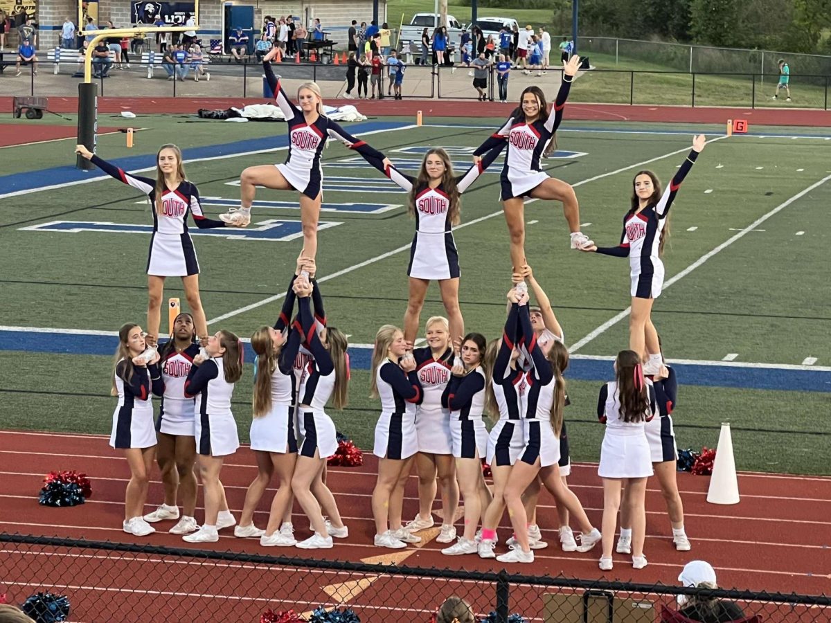 Members of the South High varsity cheerleading team performs a stunt during the football game against Northwest. Photo by Regina Wright.