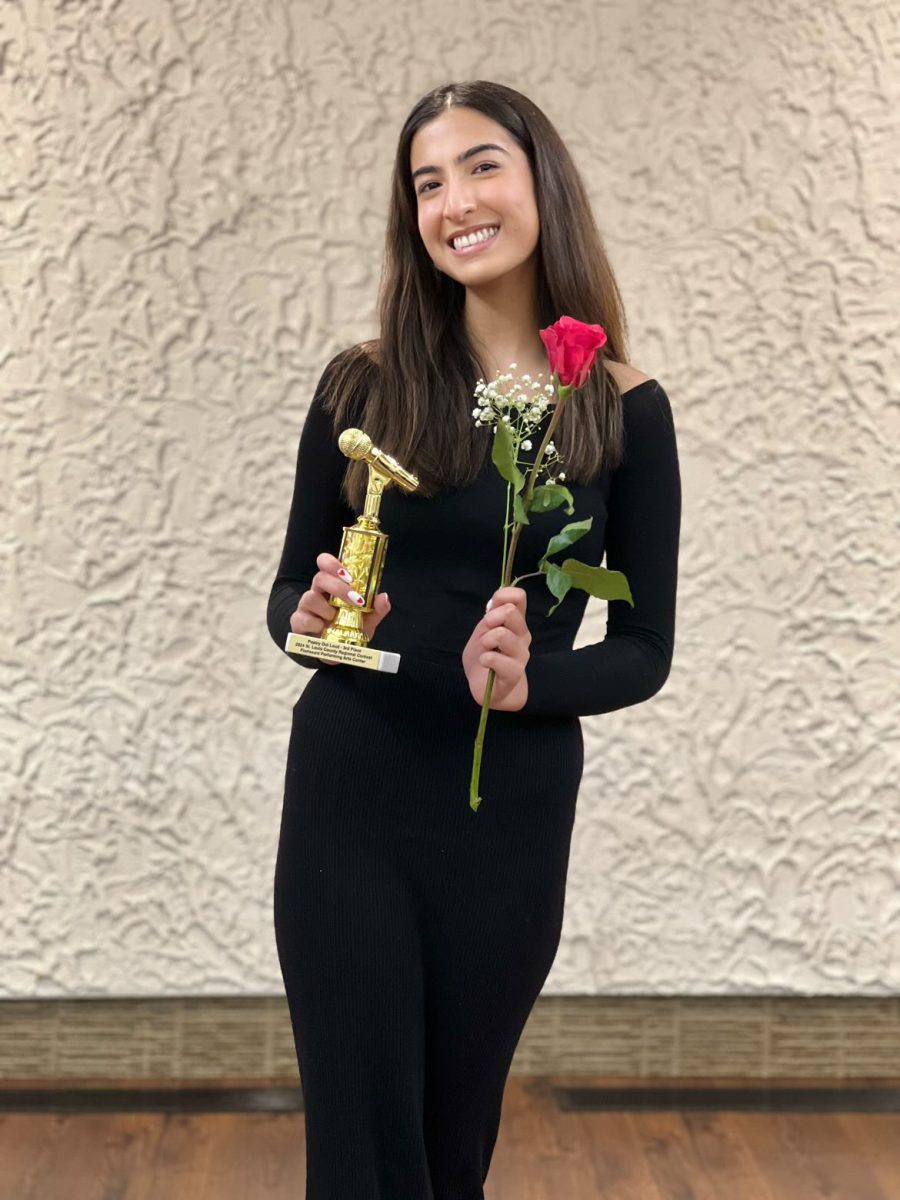 Senior Sonia Akbani holds her trophy and rose after placing third at the regional Poetry Out Loud competition. Photo courtesy of Sonia Akbani.