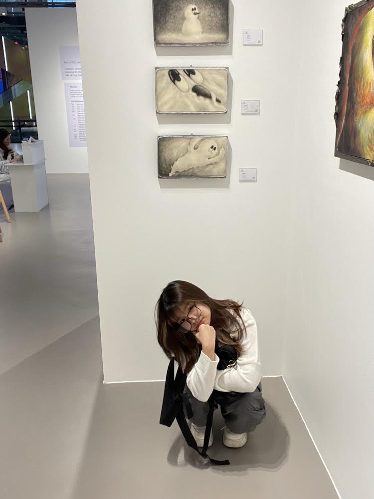 Junior Miaa Wisitthipakdeekun takes a picture while visiting an art gallery .