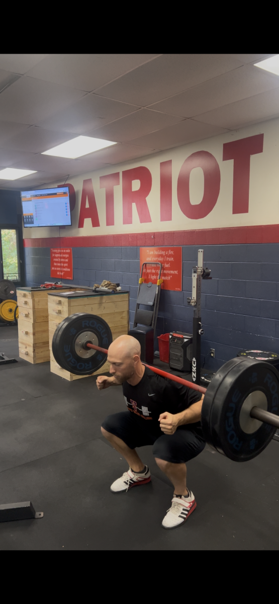 Strength and Conditioning teacher Kyle Whitcher shows off his squatting ability by squatting 225 pounds without using his hands