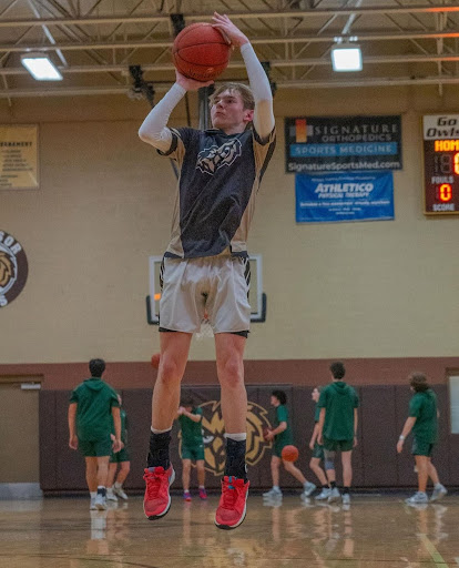 Noah Barnes leaps in the air while hitting a jump shot during pregame at Windsor High School.