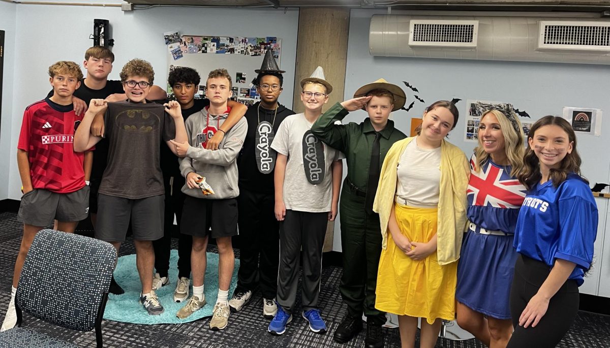 Melissa Gebhard takes a picture with her red day Geolish students, all dressed up for Halloween.