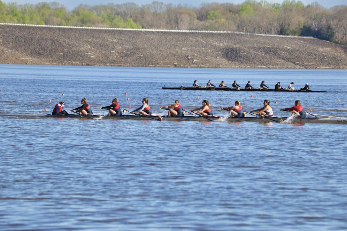 Rowing in the front of the boat, senior Sophia Cramer moves in sync with the rest of her team, making the boat glide through the water.