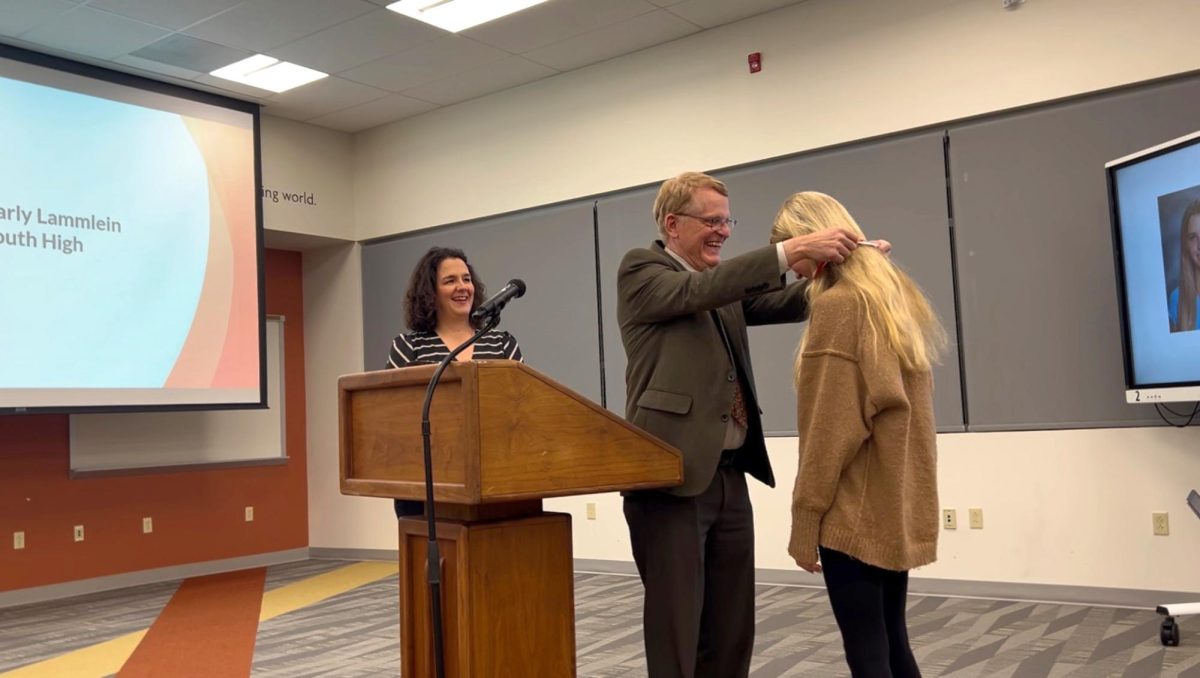 With Principal Angie Pappas-Muyco looking on, junior Carly Lammlein is presented with the Superintendent Character Award by Superintendent Keith Marty.