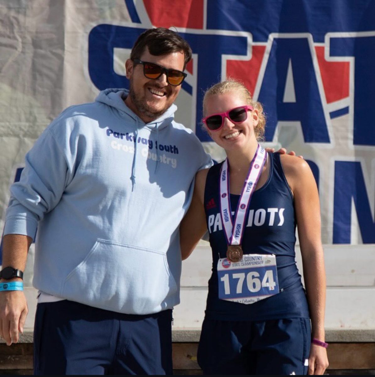 Junior Natalie Lena takes a picture with Coach Bob Klebolt after placing 24th at the state cross country meet.