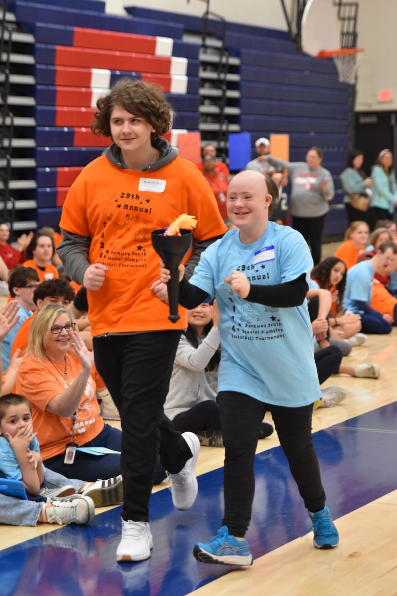 Last year, junior Maya Snarzyk runs with her buddy during the torch relay to begin Special Olympics.