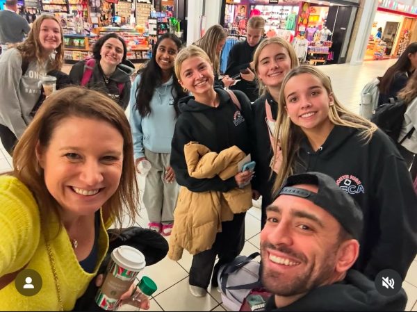 Business teachers Amy Boscan and John Barnabee take a picture with some of their business students before boarding the plane for this year's trip to NYC.