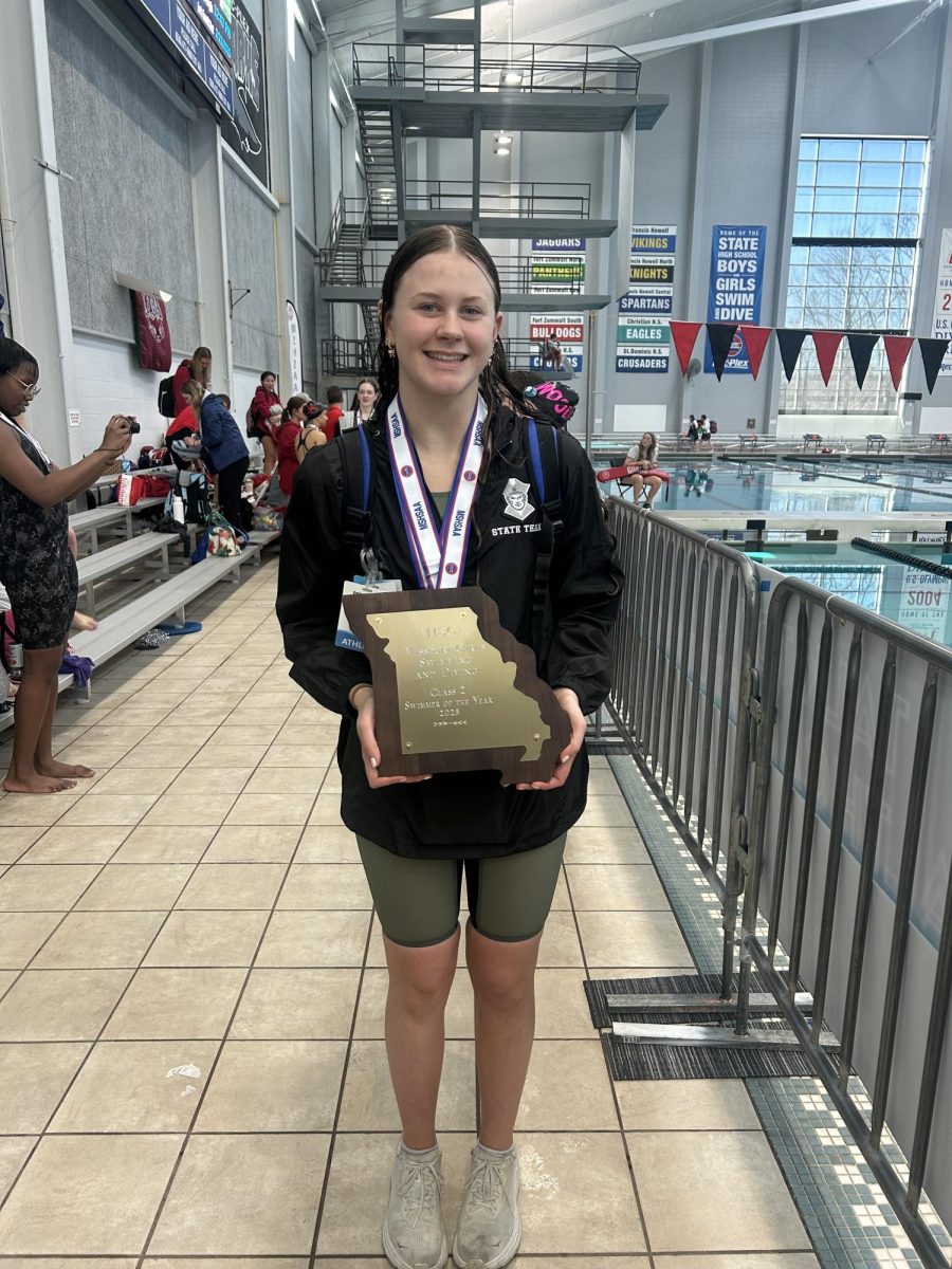 Junior Lexi Cook holds up her plaque for Swimmer of the Year at the state meet.