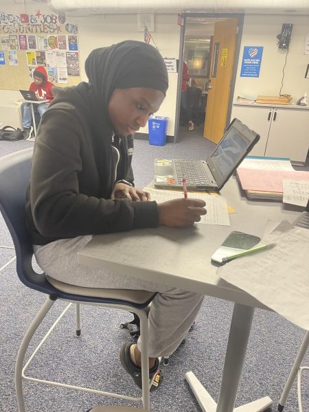 Junior Nasrah Alli works on her math homework during her lunch period. Alli spent most of her lunch periods away from the Commons during the month of Ramadan.