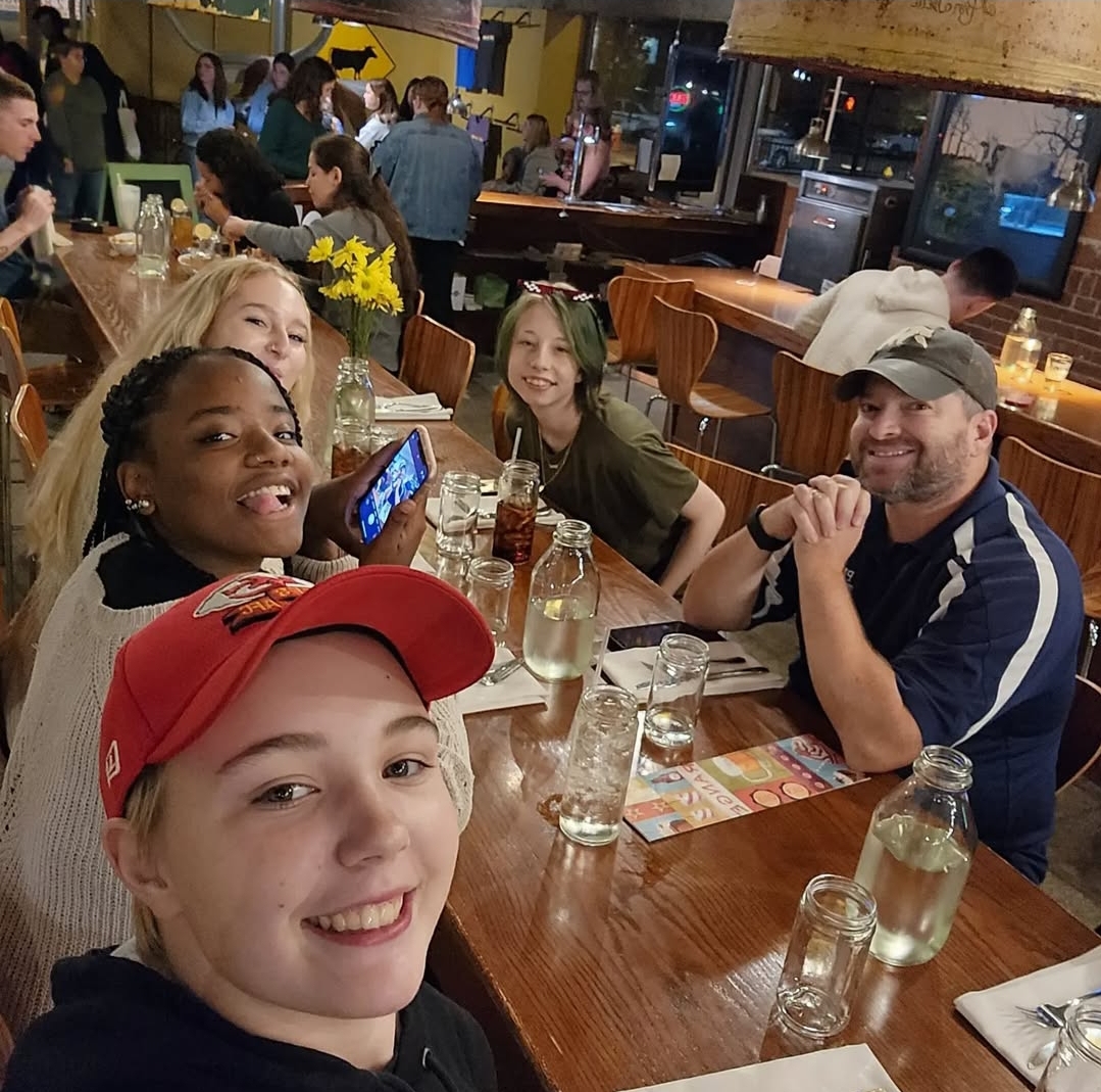 Senior Shay Fredrickson, and graduates Marci Townsend, Jamorah Triplett and Lindsey Unnerstall have lunch in downtown St. Louis with journalism teacher Mr. Brady during the National High School Journalism Conference in 2022.