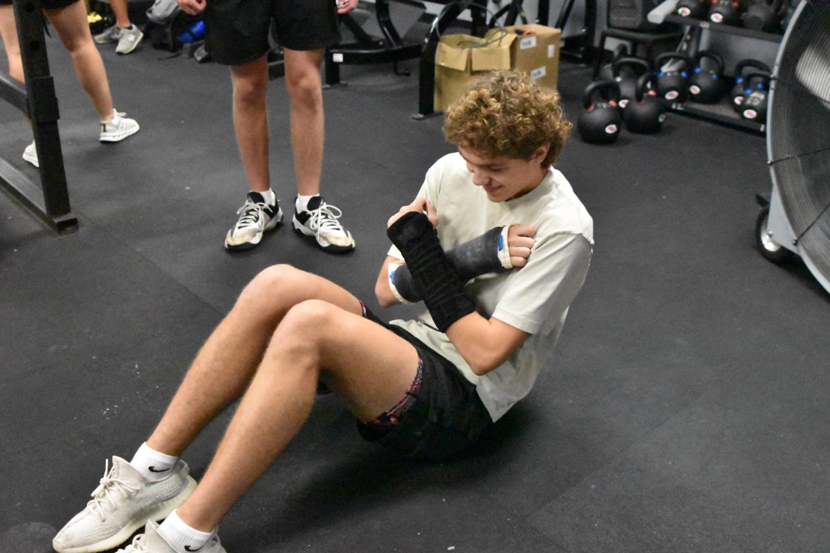 Junior Charlie Shaffer does alternative exercises in Strength & Conditioning adorned with double wrist braces