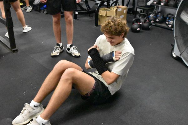 Junior Charlie Shaffer does alternative exercises in Strength & Conditioning adorned with double wrist braces