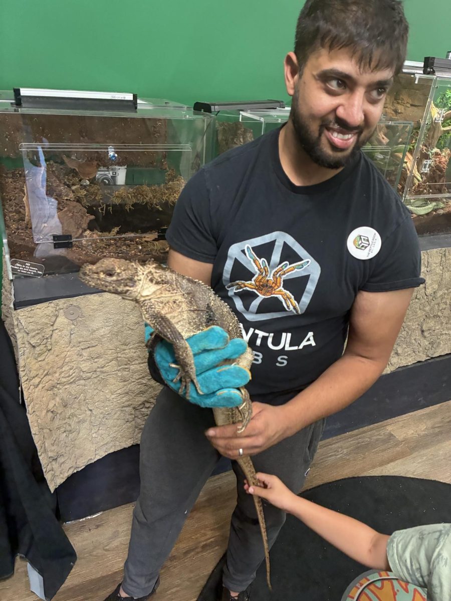 The store’s owner, Mo Dalal, shows customers a lizard. 