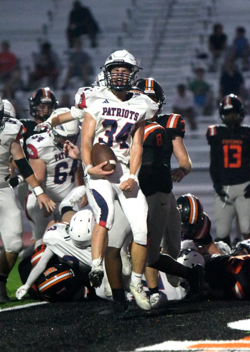Celebrating with intense emotion after charging through the defense, sophomore running back Carson Litzsinger (#34) made his mark in South's matchup against Webster Groves, Sept. 12, Friday night varsity football game. Scoring the Patriots' first touchdown of the year on a determined 3-yard run, Litzsinger shared, "It was a good run play up against Webster Groves. I was really excited and happy for the team because it was the first touchdown of the year."