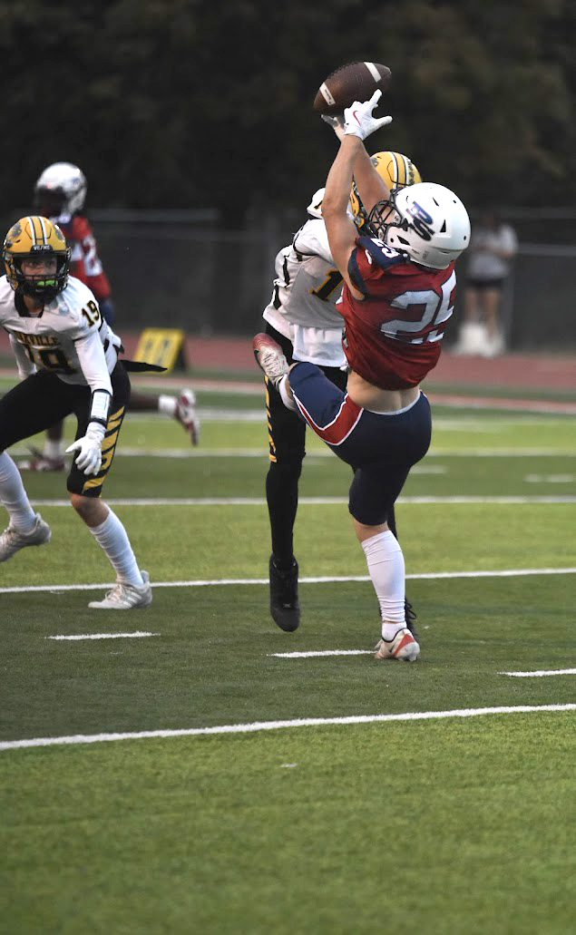 Senior cornerback Joey Morrow falls to the ground after making an interception in the game against Oakville. 