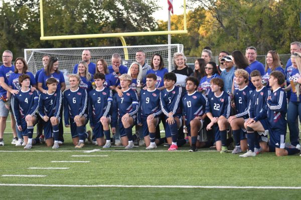 Senior soccer players pose with parents before senior night game against Seckman.