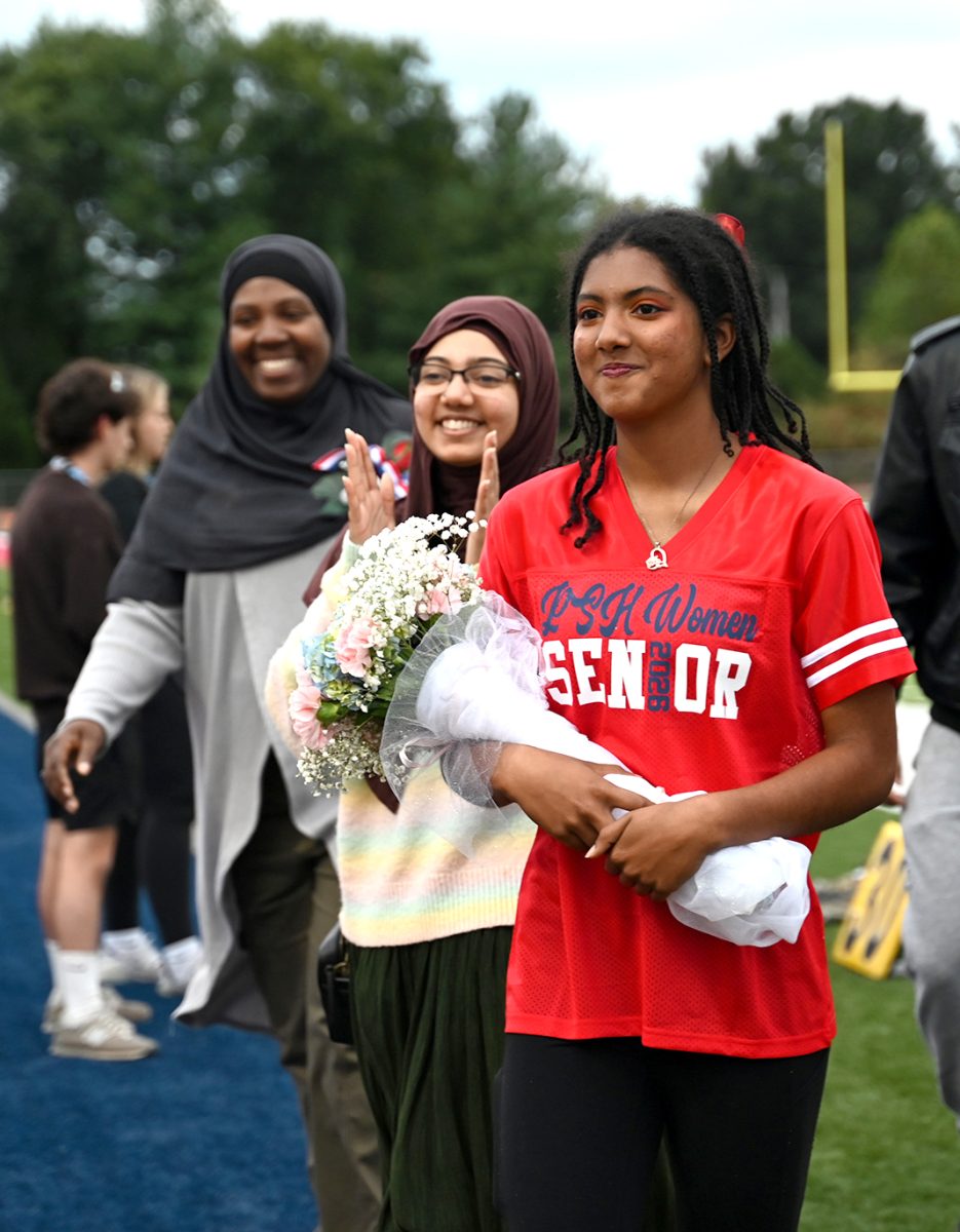 With her mom and sister cheering her, senior Maiyah Syed gets recognized on Senior Night for Color Guard, Oct. 10. "It felt pretty good [to be recognized]. I thought it was nice to have all my accomplishments laid out [by the announcer.] [I'm really going to miss] the evening practices and the bonding with the team over everything," Syed said. 