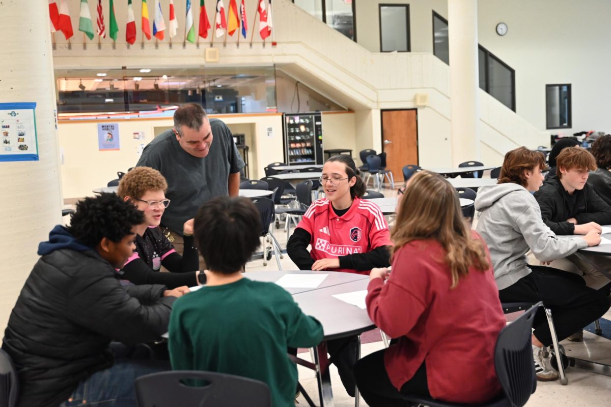 PE teacher Dave McFarland works with health students in the cafeteria after getting displaced due to renovations.