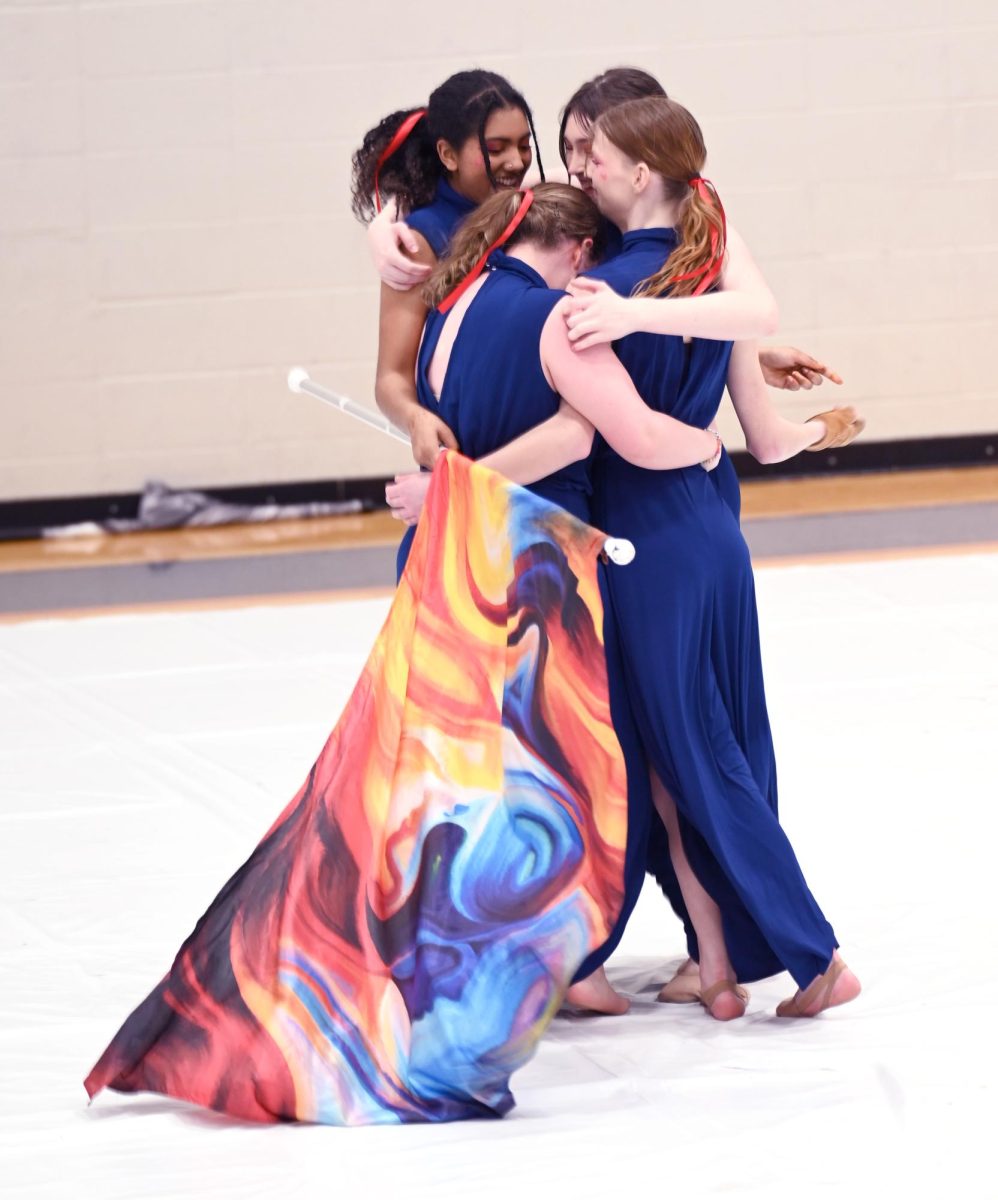 Seniors Megan Hutchins, Maiyah Syed, Lexi Horner, and Marcie Studt share an emotional embrace after their final winter guard performance on Senior Night, March 23. Senior Night marked the end of making memories together in Guard.  "I'm going to miss the community. Every single competition, it is nothing but positive vibes from everyone;. They have nothing but nice things to say. They just want you to do your best," senior Hutchins said. 