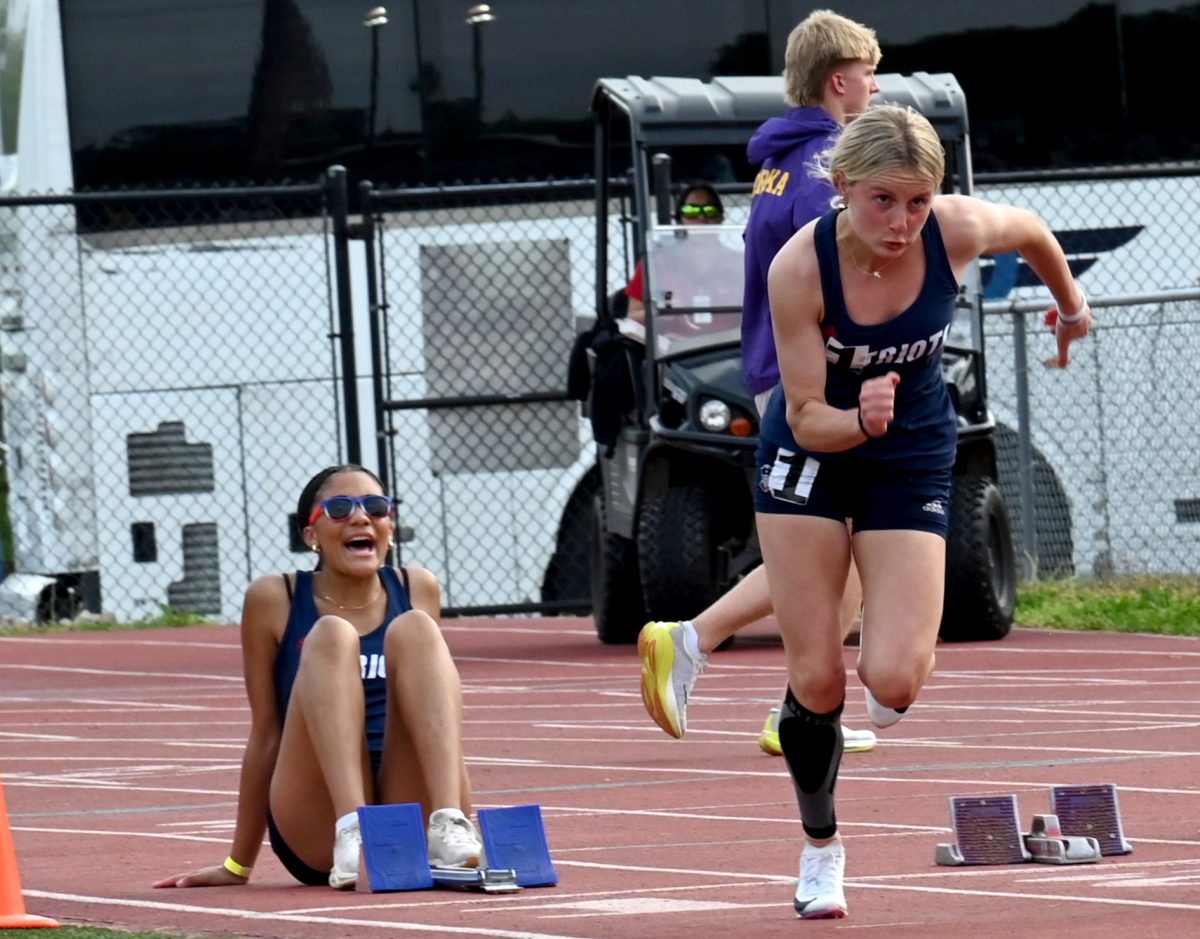 Sophomore Maria Nicoletti takes off to start her 100-meter dash, while teammate Zoey Barker holds the blocks for her at the Henle Holmes Invitational at Parkway Central. 